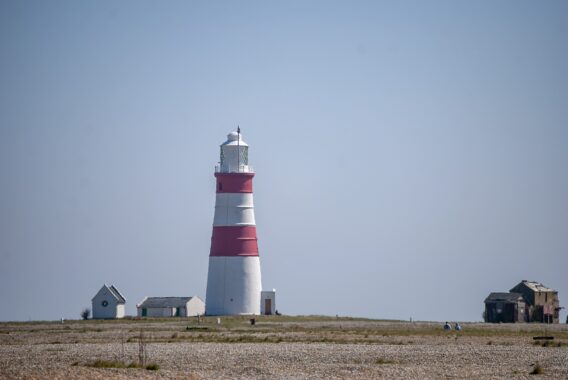 A red and white lighthouse on Orford Beach.
