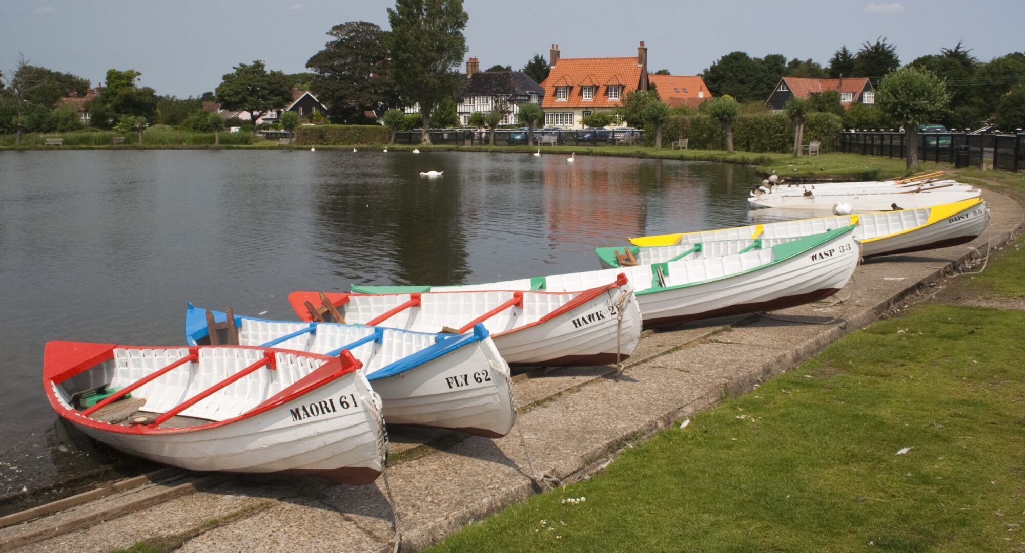 A row of boats lined up along the riverside.