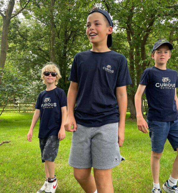 Children walking in Curious Retreats branded shirts.
