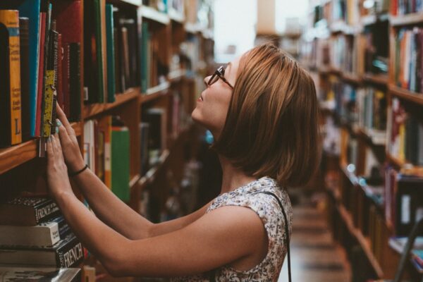 Woman looking at bookshelves.